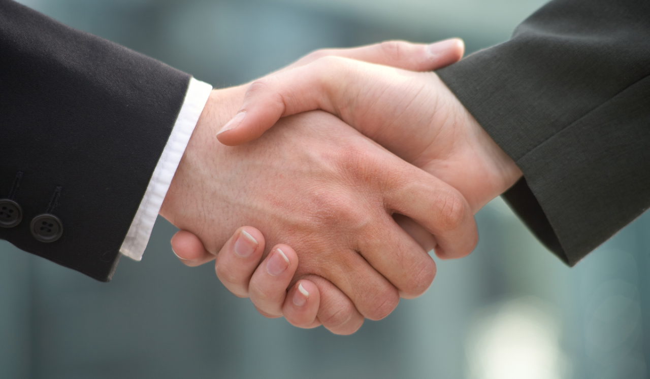 Twee partners schudden elkaars handen.