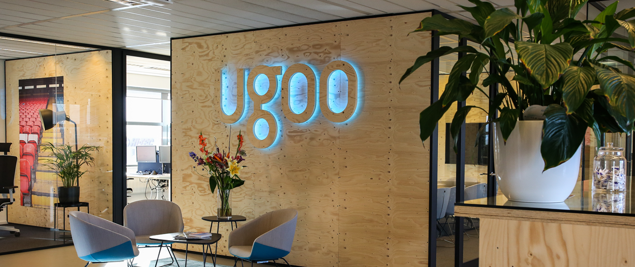 Afbeelding met Ugoo logo, stoelen, tafel, kantooromgeving, decoratief.